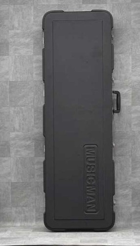 Black Ernie Ball Musicman STINGRAY used ash body guitar with maple neck, hard shell case on gray textured surface.