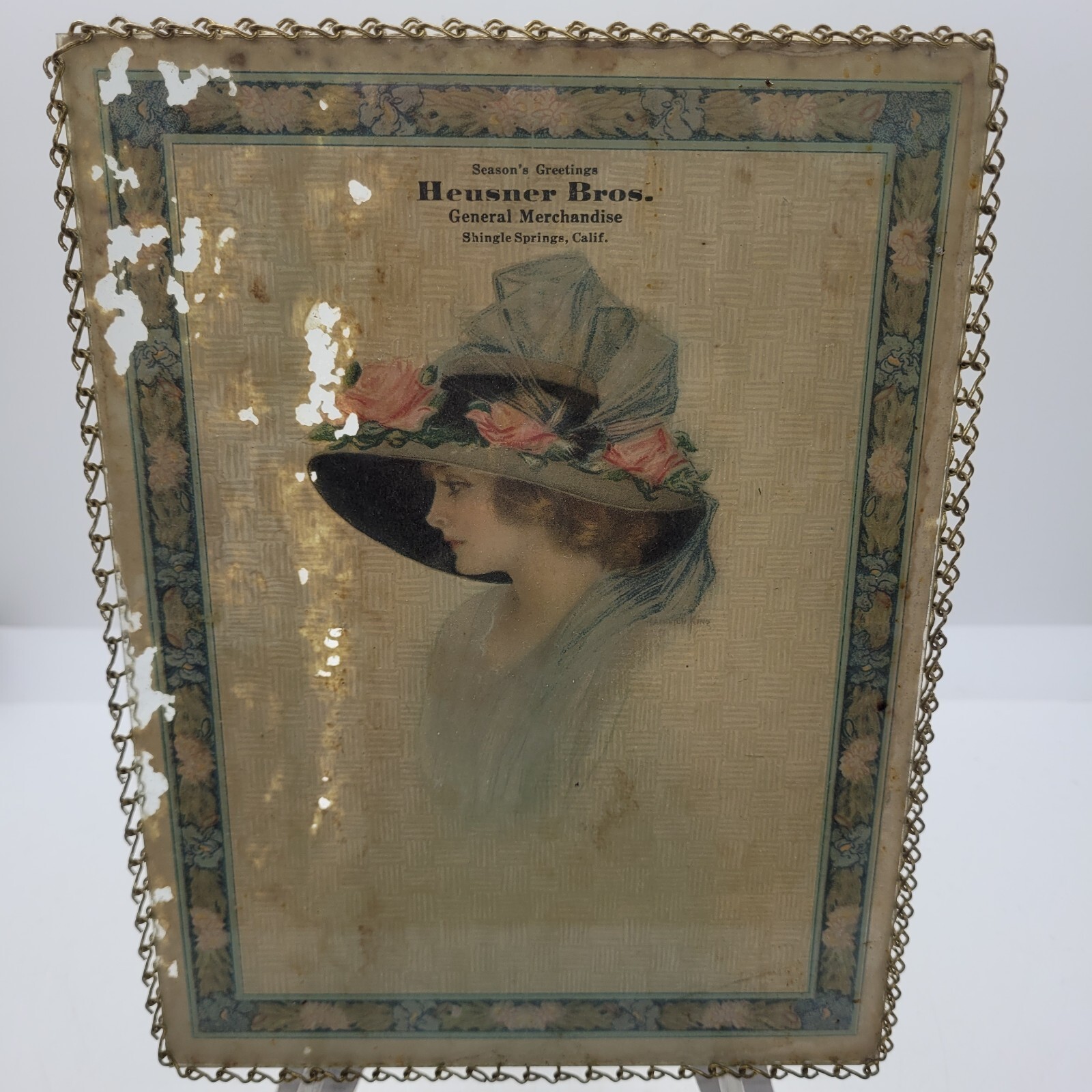 1918 Lady in Big Hat Advertisement Seasons Greetings Heusner Bros. Store