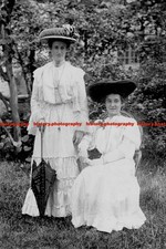 F004328 Two women in the garden with white dresses and big hats Umbrella in one