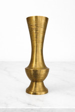 A genuine vintage brass ribbed bud vase with that perfect Hollywood Regency glam — the kind of object that anchors a shelf instantly.