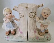 Porcelain Book Ends Hummel Style.  Boy And Girl Carving Initials In Tree