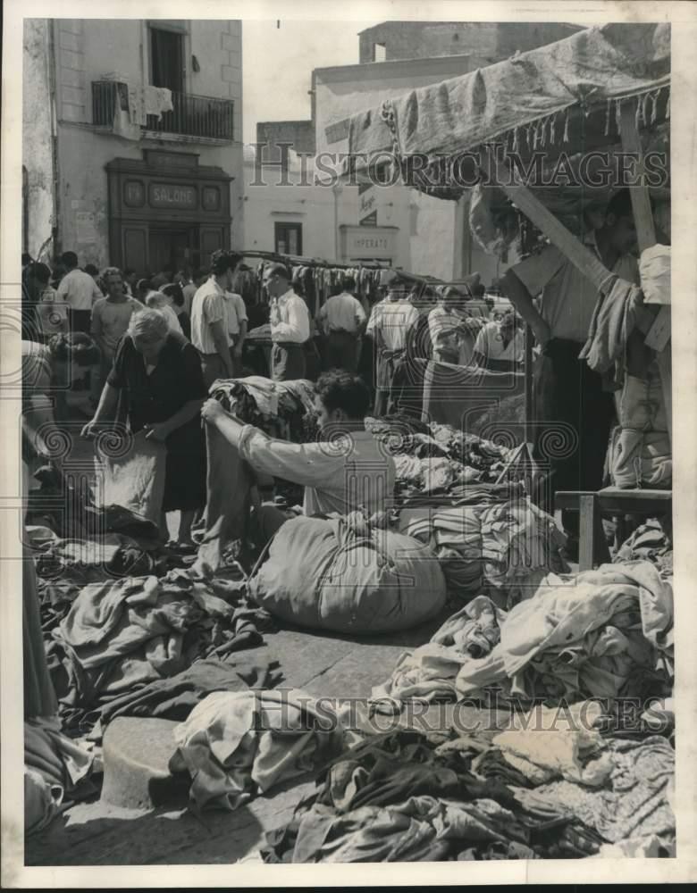 1953 Press Photo New and Secondhand Clothing Piled in Street of City in Italy