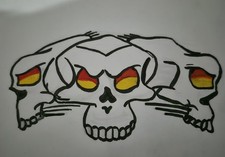 Tattoo Flash Sheet Art Design Featuring Three Skulls with Red and Yellow Eyes