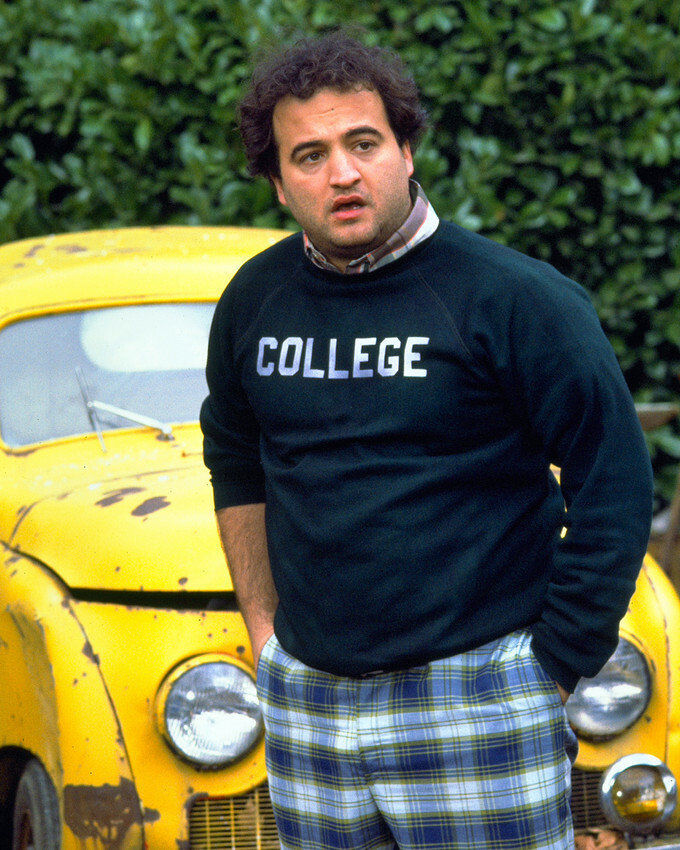 John Belushi in Animal House in front of classic car wearing