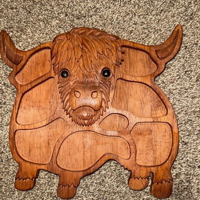 Unbranded wooden charcuterie board has a carved design in relief with the shape