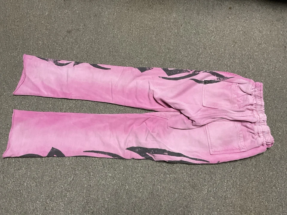 es un par de pantalones deportivos Golden Flame en rosa con un gráfico de llama negra Foto 2 de 3