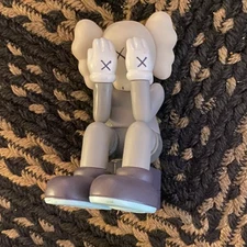 Kaws Figure Companion Passing Through Gray Seated Hands Covering Face No Box