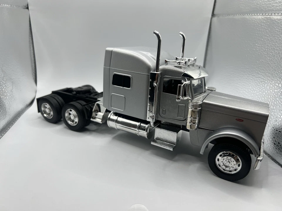 Camión Peterbilt 389 con remolque de plataforma plateada metálica. Foto 3 de 4