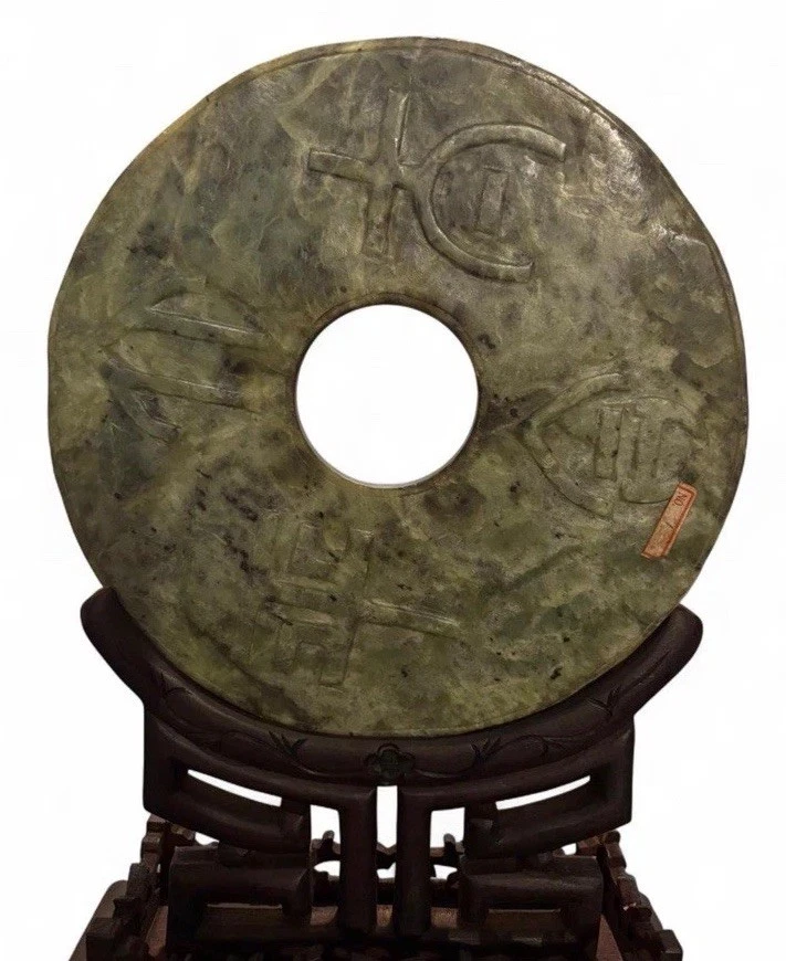 Disco bi de jade verde espinaca sobre soporte de madera dura protección y armonía de jade chino Foto 3 de 4