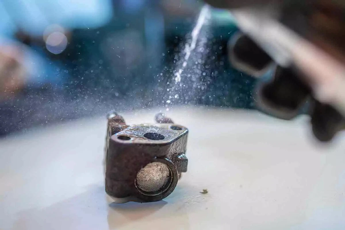 An EGR valve being sprayed with throttle body cleaner.