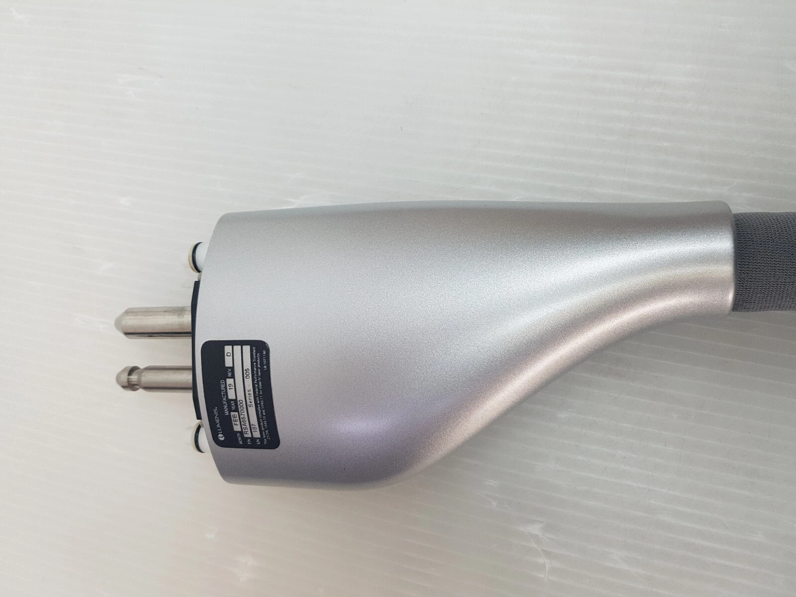 Silver connector housing with Lumenis rating plate and two metal pins