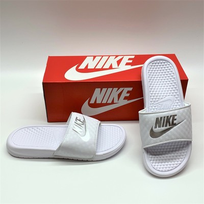 white and silver nike slides