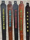 Brown leather rifle sling with black and red text, including “Springfield,” “Remington,” and “Savage” in bold letters.