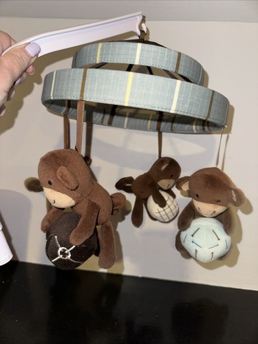 Mobile musicale Lambs & Ivy - Palline che tengono scimmie, blu, marrone e beige.