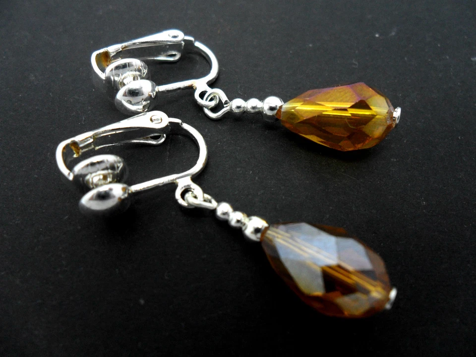 A PAIR OF SHORT AMBER GLASS CRYSTAL TEARDROP CLIP ON EARRINGS. NEW. - Image 1 of 1