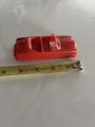 Red vintage 1950s BHS plastic convertible car with black interior, shown beside a yellow measuring tape for scale.
