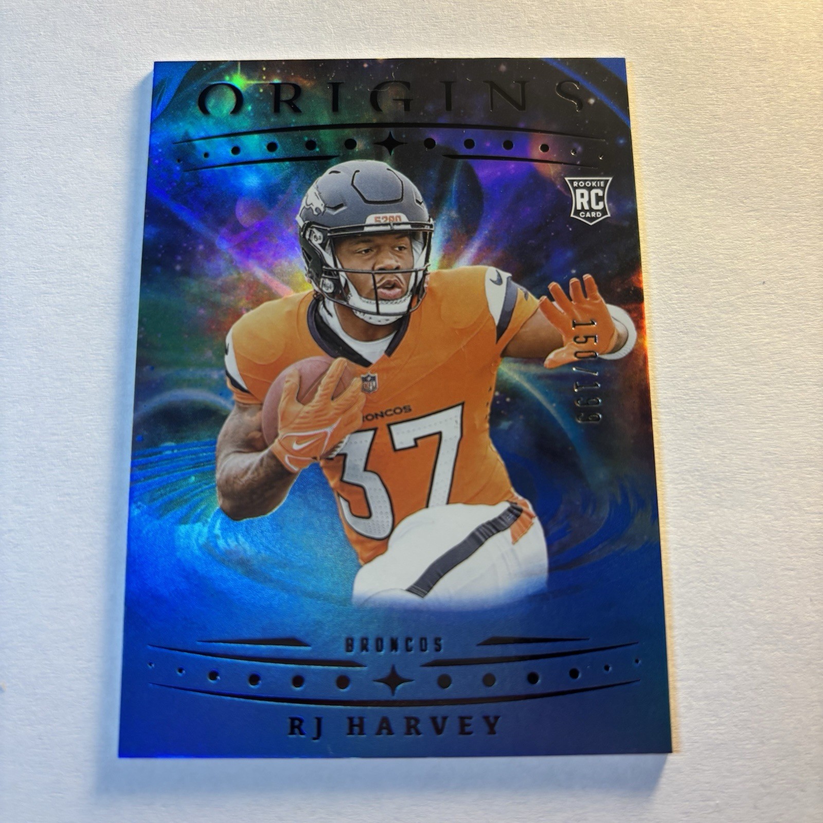 2025 Panini Origins - Rookies RJ Harvey, RJ Harvey #141 Holo Blue /199 (RC)