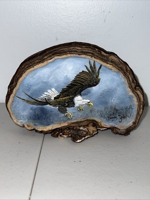 Painted bald eagle on wood or a natural material with a ''live edge''.