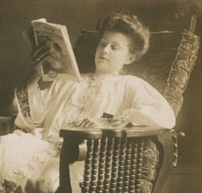 WOMAN POSED READING GOOD HOUSEKEEPING MAGAZINE. PHOTO CIRCA 1900.
