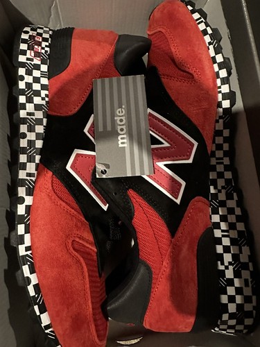 Red and black New Balance 1300 sneakers size 9 with white laces, harajuku-patterned rubber soles, and gray size tag.