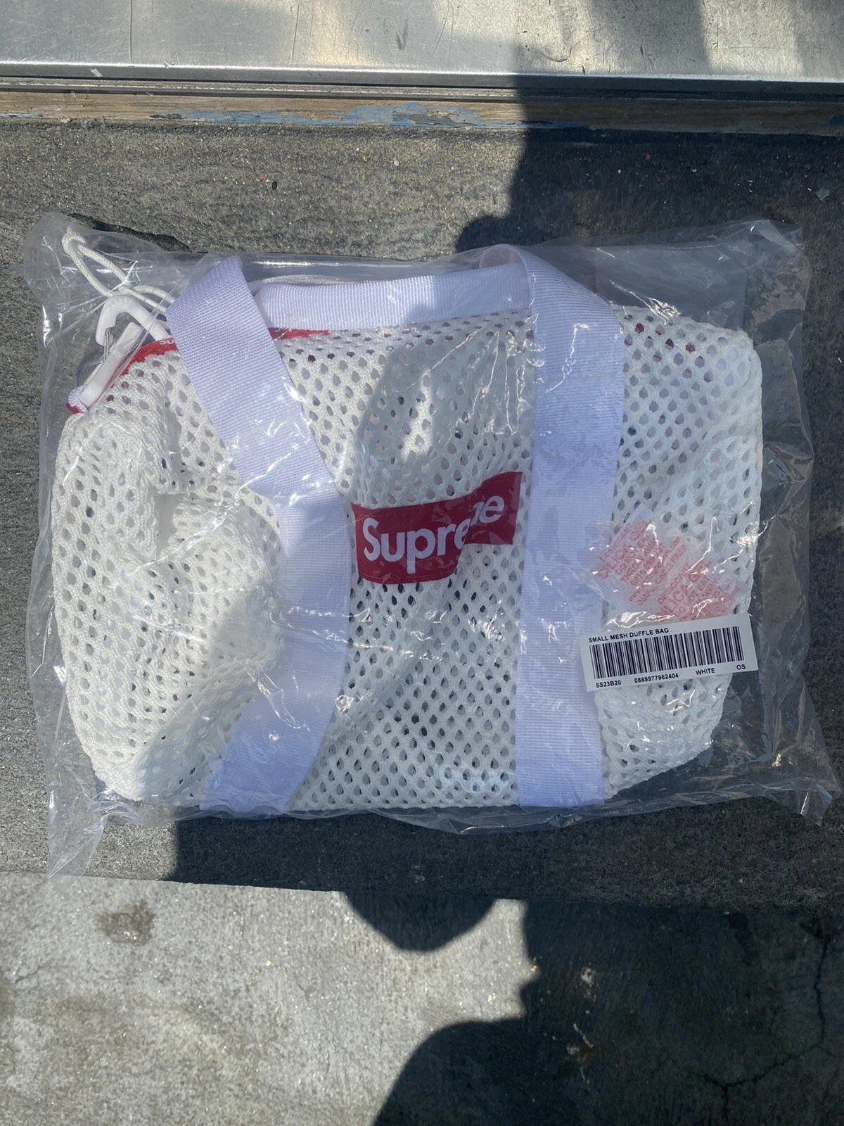 Mini sac de sport en maille suprême blanc à la main
