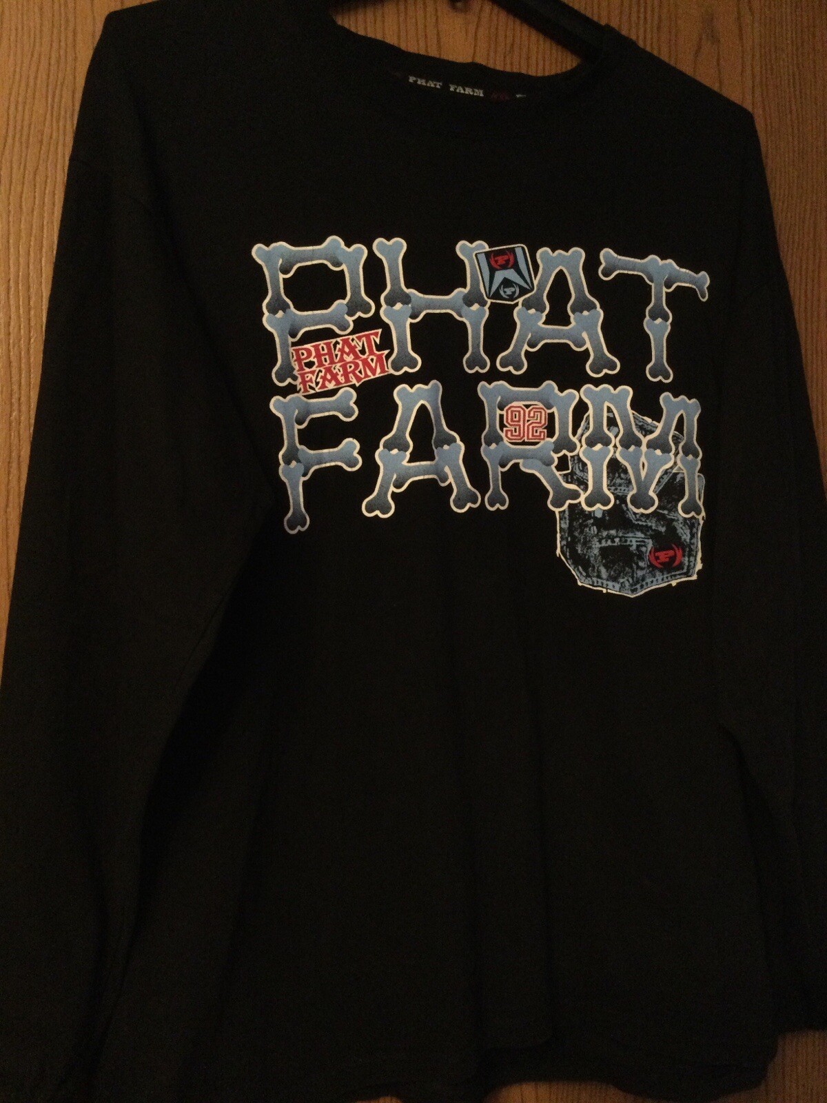 Black Phat Farm shirt with blue “PHAT FARM” text, bone graphic, and red-black skull design on sleeve, size XL.