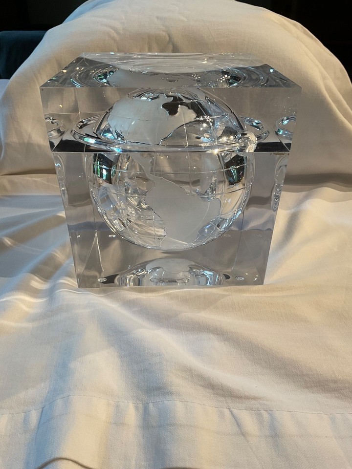 A lucite globe-shaped ice bucket that doubles as a desk sculpture — pure 1960s space-age optimism in barware form.