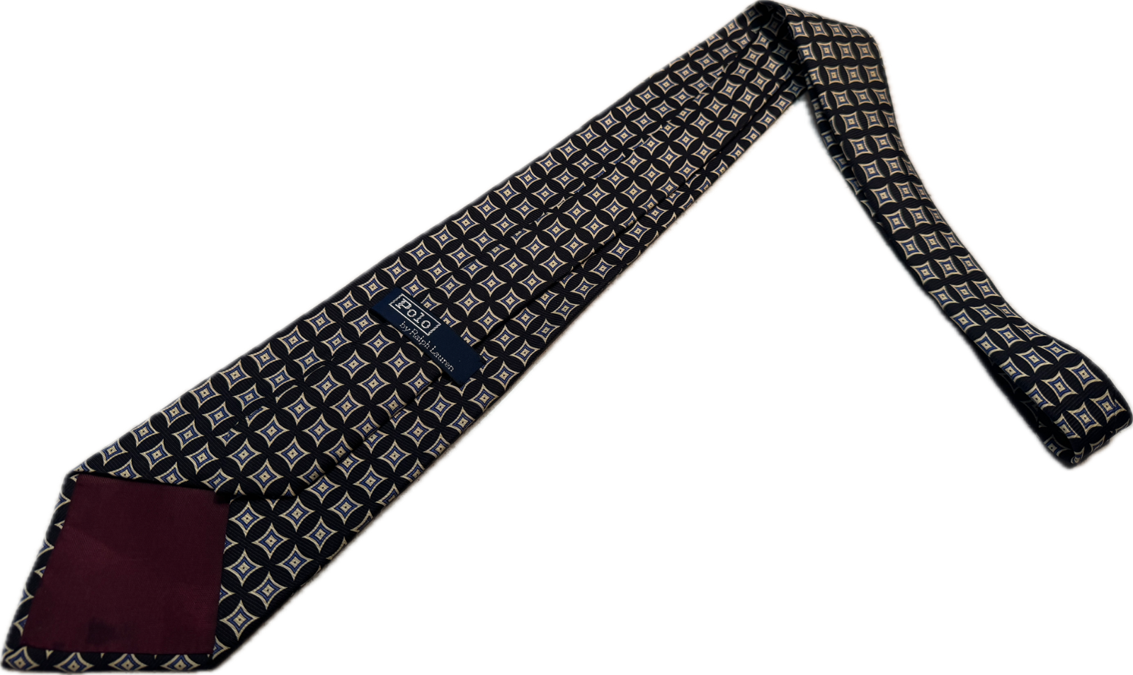 Black silk tie with white geometric diamond pattern, hand made in USA, displayed against a burgundy neck.