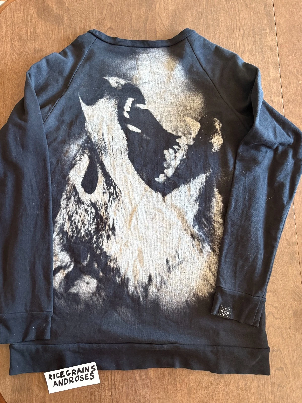 Black crewneck sweater size medium with white wolf head graphic, front pocket, and “DROP DEAD CLOTHING WOLF” text on sleeve.