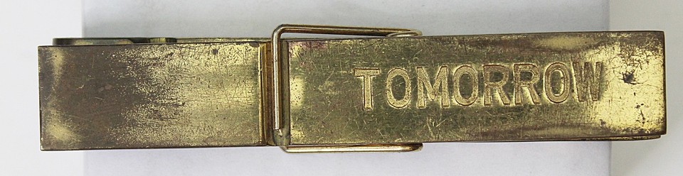 Made-in-Italy brass memo clip engraved 'TODAY TOMORROW' — a beautifully absurdist little object that's equal parts functional antique and existential joke.