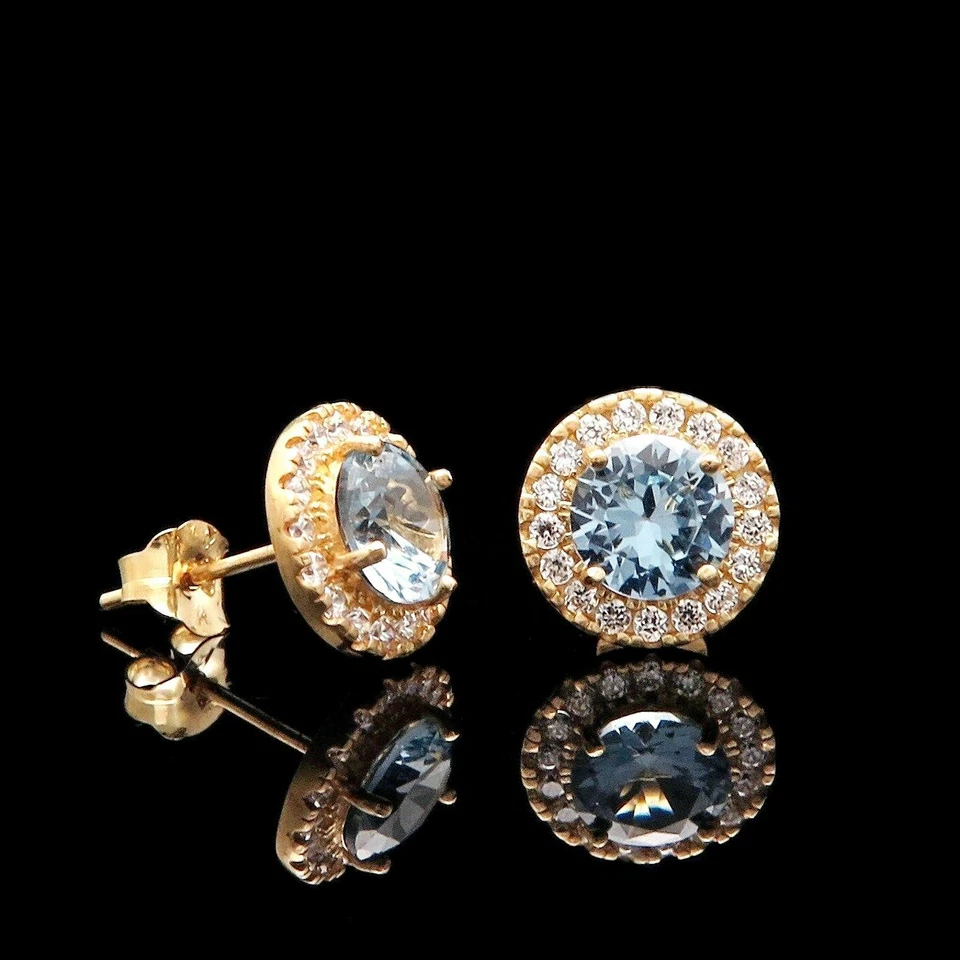 Aretes redondos de oro amarillo de 14 k con halo de diamantes simulados de aguamarina azul de 1 quilate Foto 2 de 4