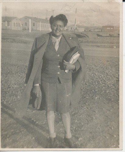 PORTRAIT OF AFRICAN-AMERICAN WOMAN ON ARMY BASE W/ SCHOOL BOOKS