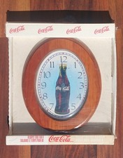 Horloge murale Coca-Cola design bouteille ovale finition bois dans sa boîte d'origine