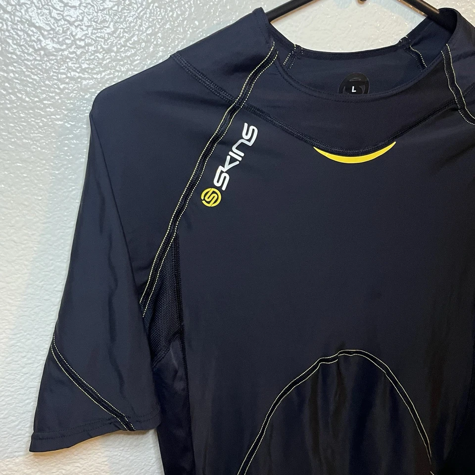 Top de compresión manga corta SKINS A400 para hombre en negro y amarillo talla grande Foto 3 de 4