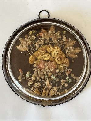 Vintage dried flower arrangement encased in a round, convex glass dome frame