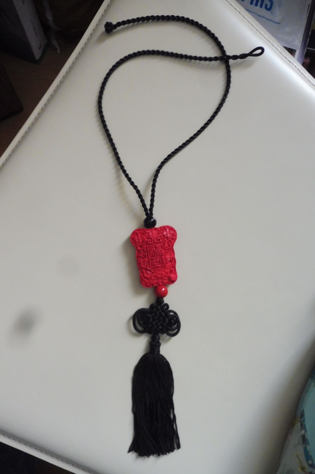 Collier perle cinnabar rouge Asie avec cordon ajustable et pompon noir