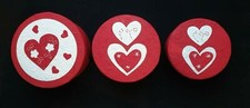 Trzy okrągłe czerwone pudełka upominkowe ozdobione miłością serca
