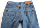 Back view of VTG Lucky Brand jeans in medium wash brown with paint splatter on right leg and tan leather patch on waistband.