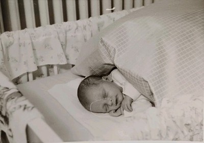 Zartes Baby Neugeborenes liegt schlafend im Gitterbett schläft Bett Altes Foto