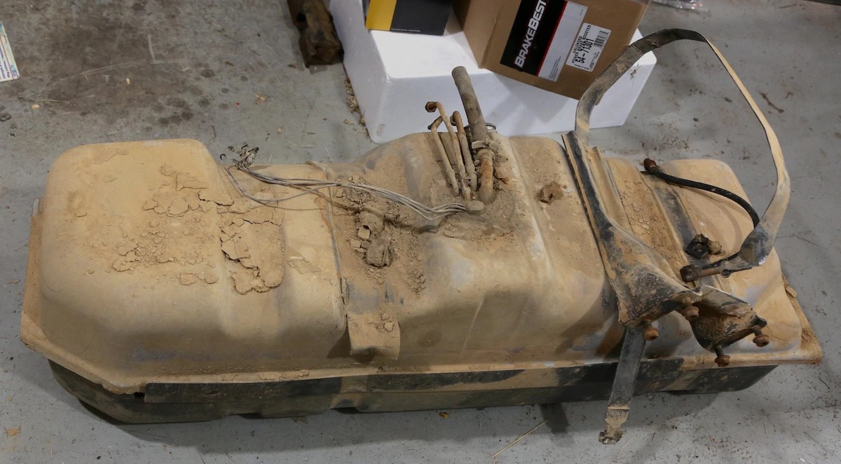 1992 Chevy 1500 fuel tank covered in dirt from years of use.