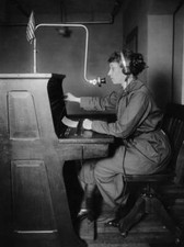 Woman, wearing a hands free headset, operates a telephone switchbo Old Photo