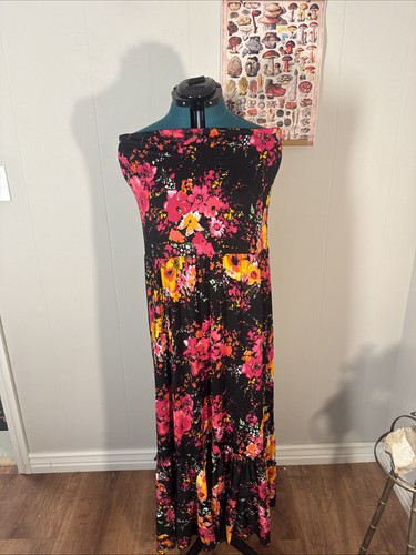Black vintage fabric with small colorful floral print, tiered waist, and “Made in USA” label on mannequin.