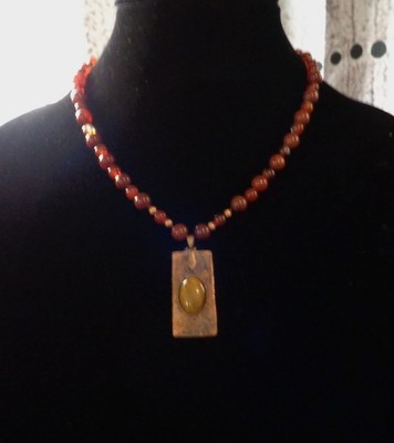 Artisan crafted,1 ¾ x ¾'' hammered, antiqued copper pendant with applied Tiger ey