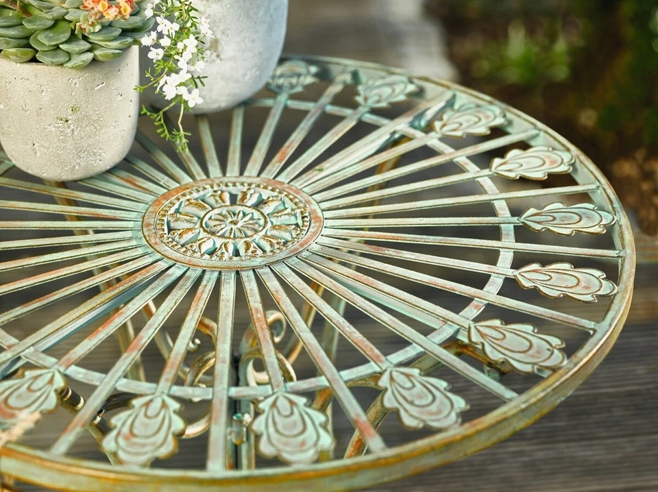 Mesa de bistró de metal con patas curvas, corazón desplazado y motivo de cola de pavo real Foto 3 de 4