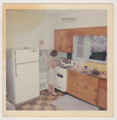 Frau bereitet Abendessen in gemütlicher Retro-Küchenszene vor Vintage Abend R...