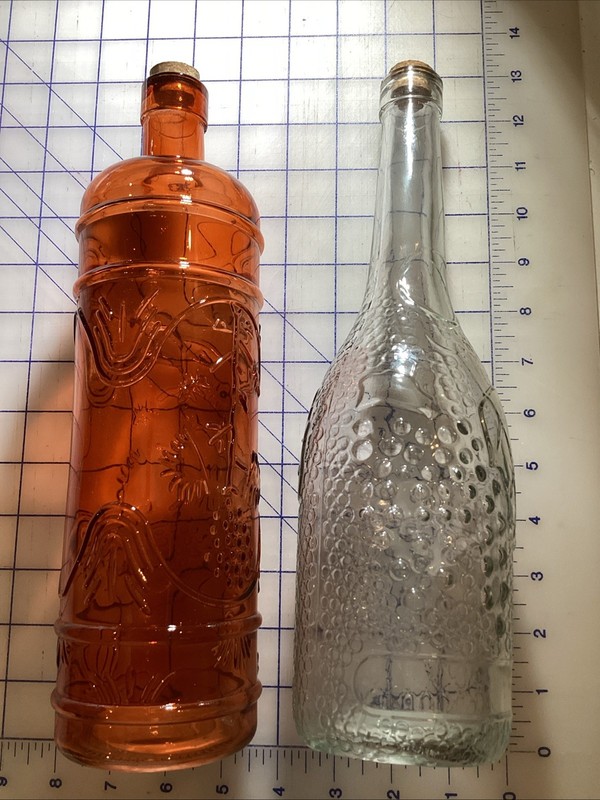 Decorative 2 colored glass bottles 1 clear and 1 rust color 13”