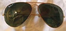 This is a pair of vintage B L Ray-Ban Aviator sunglasses with a gold-toned...