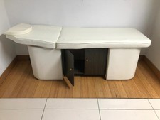 Spa facial massage bed with built in storage cabinets.