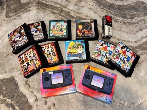NeoGeo Pocket handheld consoles(2) with games(9) and cord.  Blue Stone color