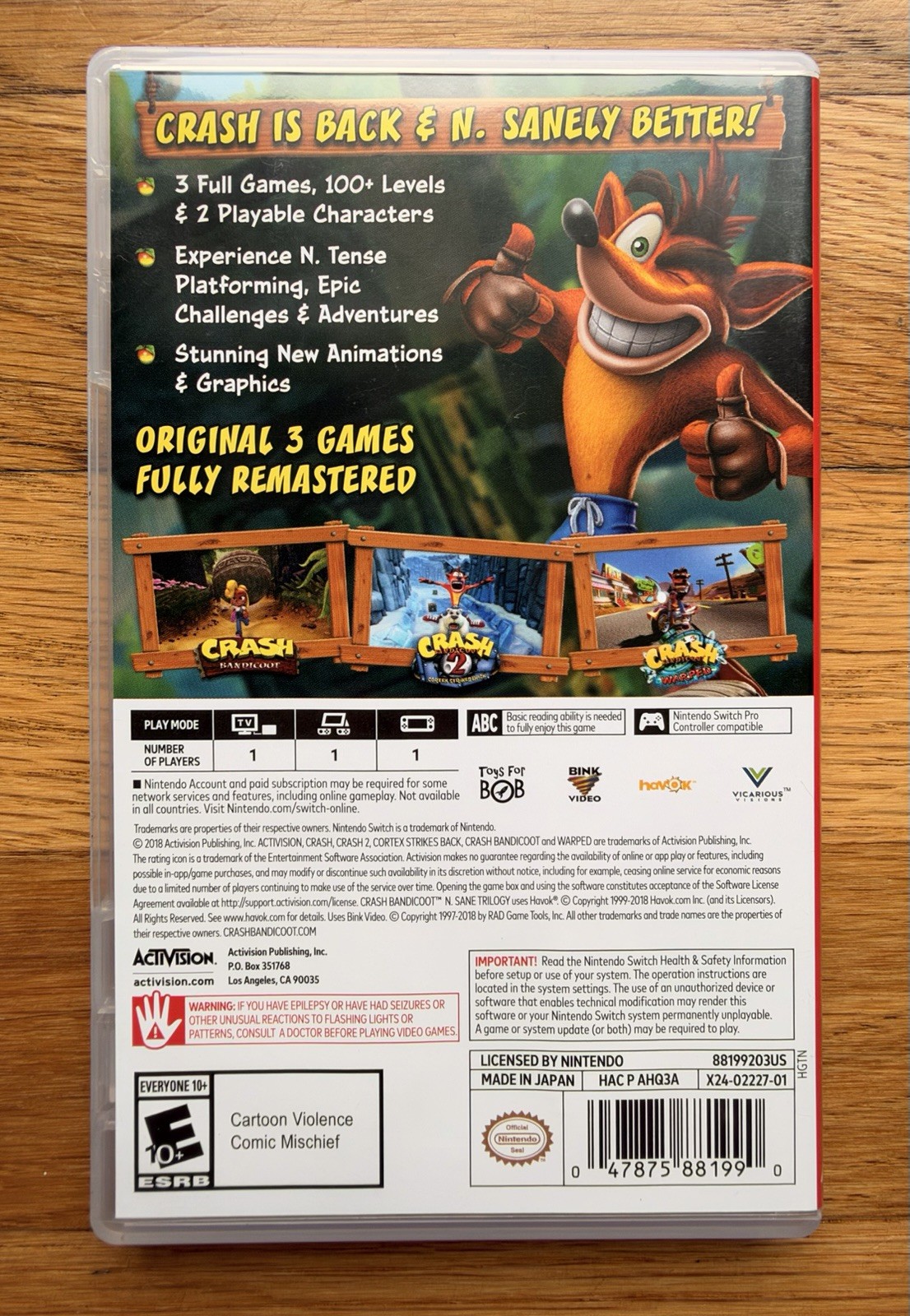 Black Switch case for Crash Bandicoot N Sane Trilogy with cover art of Crash, spikes, and colorful platform scenes.